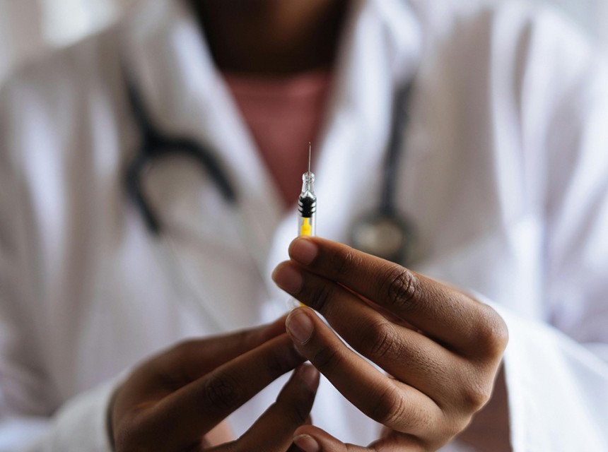 A doctor holds a syringe full of medication.